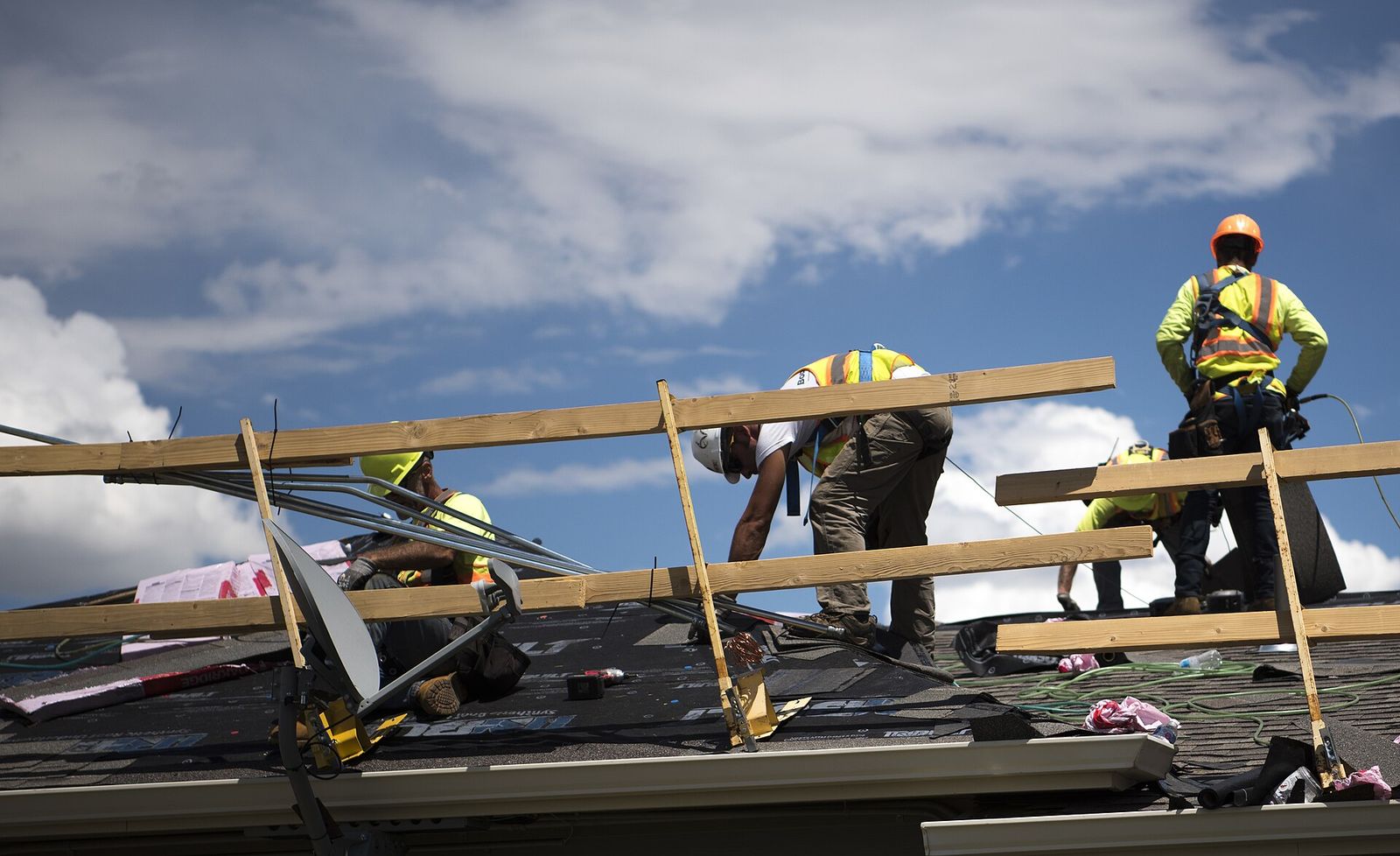 Crew setting new decking on a roof